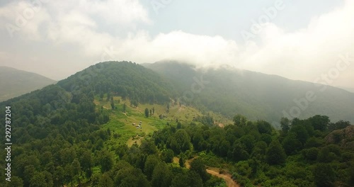 An aerial shot of a group of people camping over a mountain 2 An unveiling shot of some offroad 4wheel cars and visitors camp area in a great green nature under beautiful clouds   photo