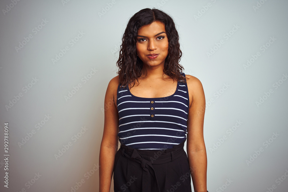 Transsexual transgender woman wearing striped t-shirt over isolated white background puffing cheeks with funny face. Mouth inflated with air, crazy expression.