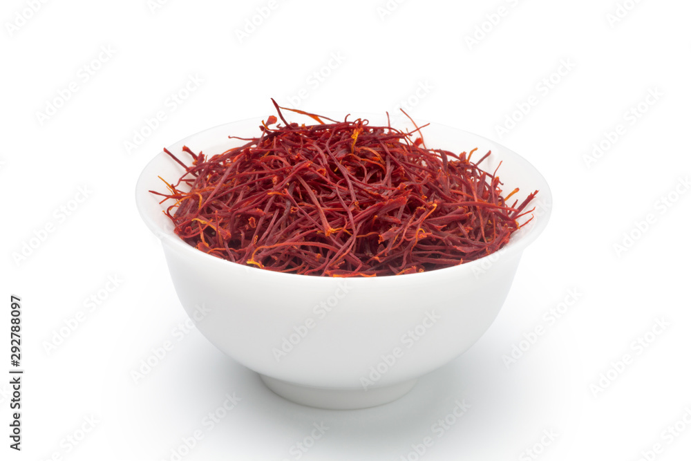 Fototapeta premium Dried saffron in a white ceramic cup. Isolated on white background.