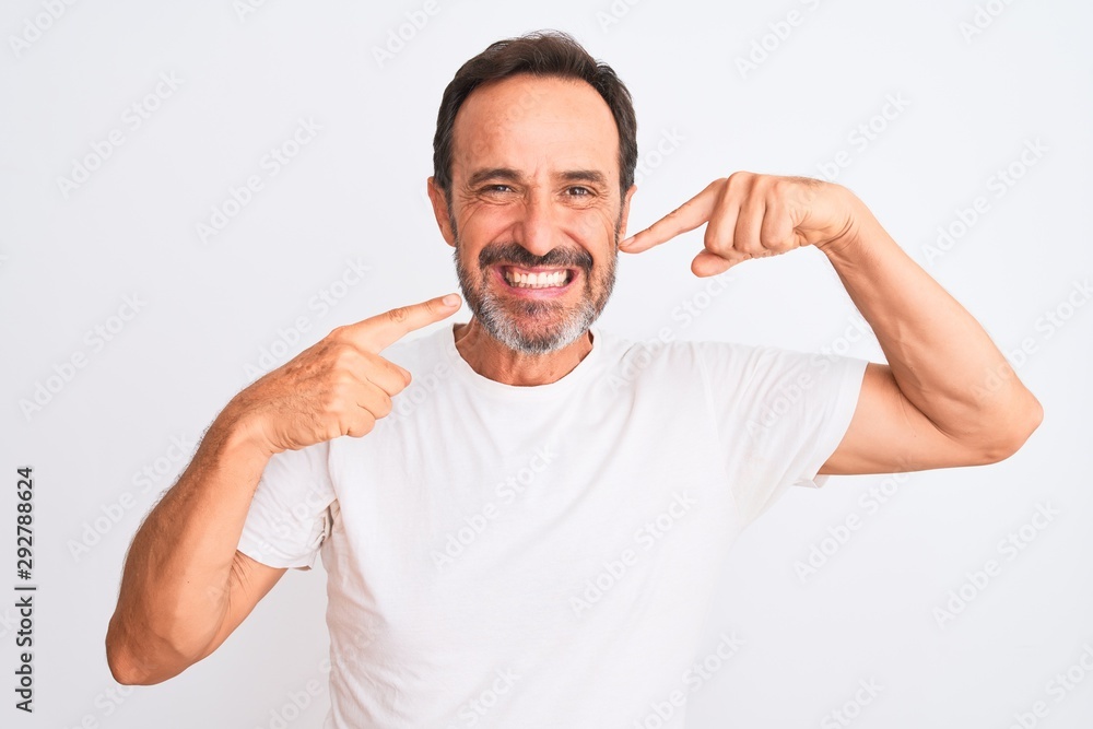 Middle age handsome man wearing casual t-shirt standing over isolated white background smiling cheerful showing and pointing with fingers teeth and mouth. Dental health concept. Middle age handsome man wearing casual t-shirt standing over isolated white background smiling cheerful showing and pointing with fingers teeth and mouth. Dental health concept.
