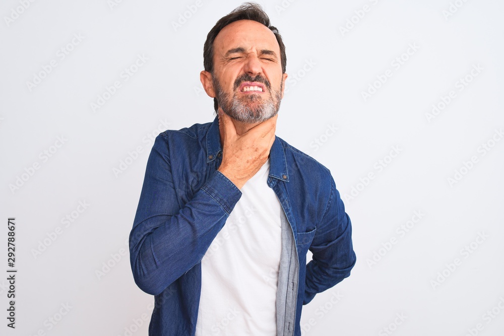 Middle age handsome man wearing blue denim shirt standing over isolated white background Touching painful neck, sore throat for flu, clod and infection Middle age handsome man wearing blue denim shirt standing over isolated white background Touching painful neck, sore throat for flu, clod and infection