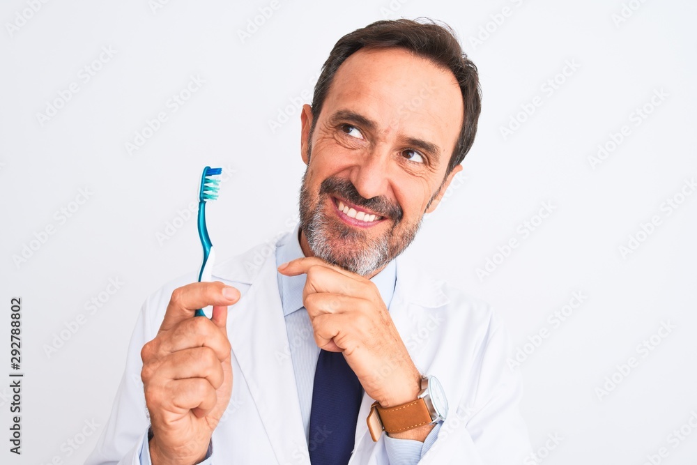 Middle age dentist man holding toothbrush standing over isolated white background serious face thinking about question, very confused idea Middle age dentist man holding toothbrush standing over isolated white background serious face thinking about question, very confused idea