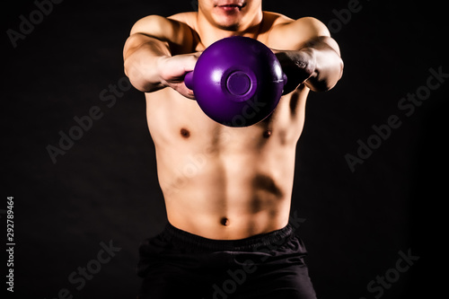 sport man at fitness gym club doing exercise for arms with kettlebell and showing muscle bodybuilding on black backgrounds, fitness concept, sport concept