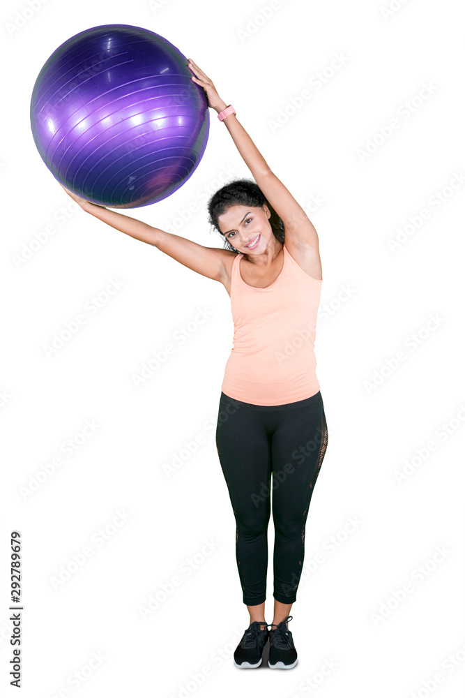 Indian woman exercising with a yoga ball on studio Indian woman exercising with a yoga ball on studio