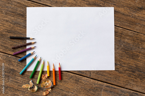 colorful colored pencil and white paper  on wooden background photo