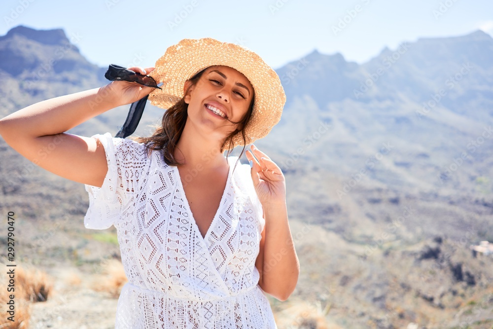 Young beautiful woman enjoying summer vacation on mountain landscape, traveler girl sunbathing with open arms