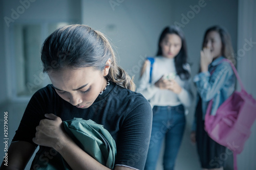 Sad teenage girl bullied with her friends photo