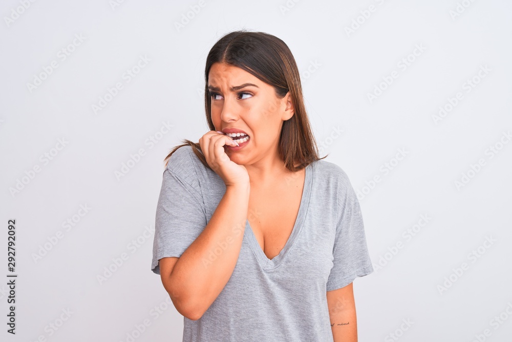 Portrait of beautiful young woman standing over isolated white background looking stressed and nervous with hands on mouth biting nails. Anxiety problem. Portrait of beautiful young woman standing over isolated white background looking stressed and nervous with hands on mouth biting nails. Anxiety problem.