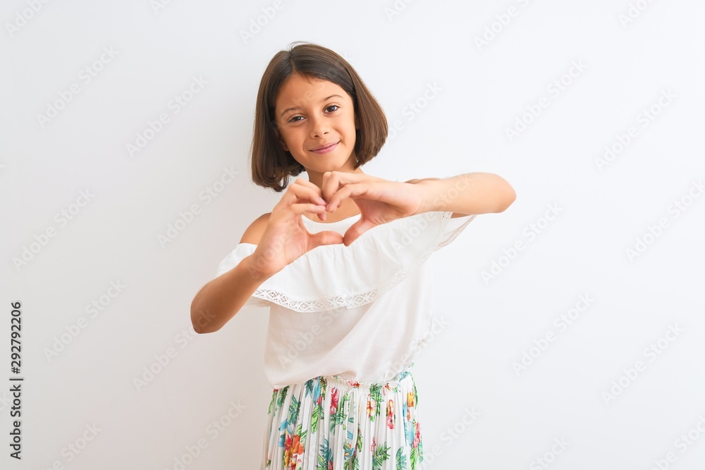 Young beautiful child girl wearing casual dress standing over isolated white background smiling in love doing heart symbol shape with hands. Romantic concept. Young beautiful child girl wearing casual dress standing over isolated white background smiling in love doing heart symbol shape with hands. Romantic concept.