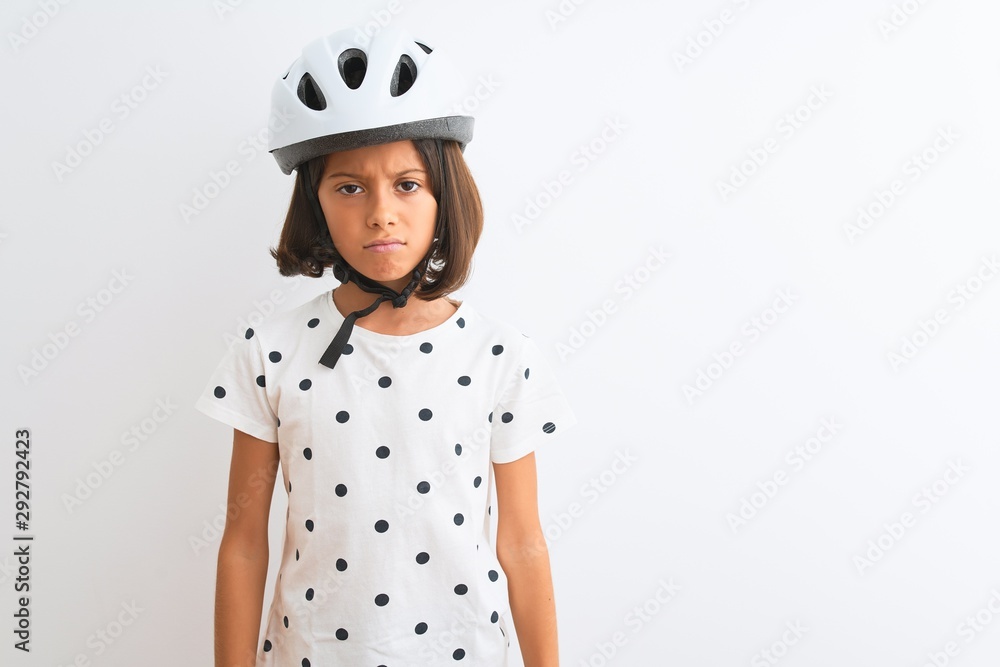 Beautiful child girl wearing security bike helmet standing over isolated white background skeptic and nervous, frowning upset because of problem. Negative person. Beautiful child girl wearing security bike helmet standing over isolated white background skeptic and nervous, frowning upset because of problem. Negative person.