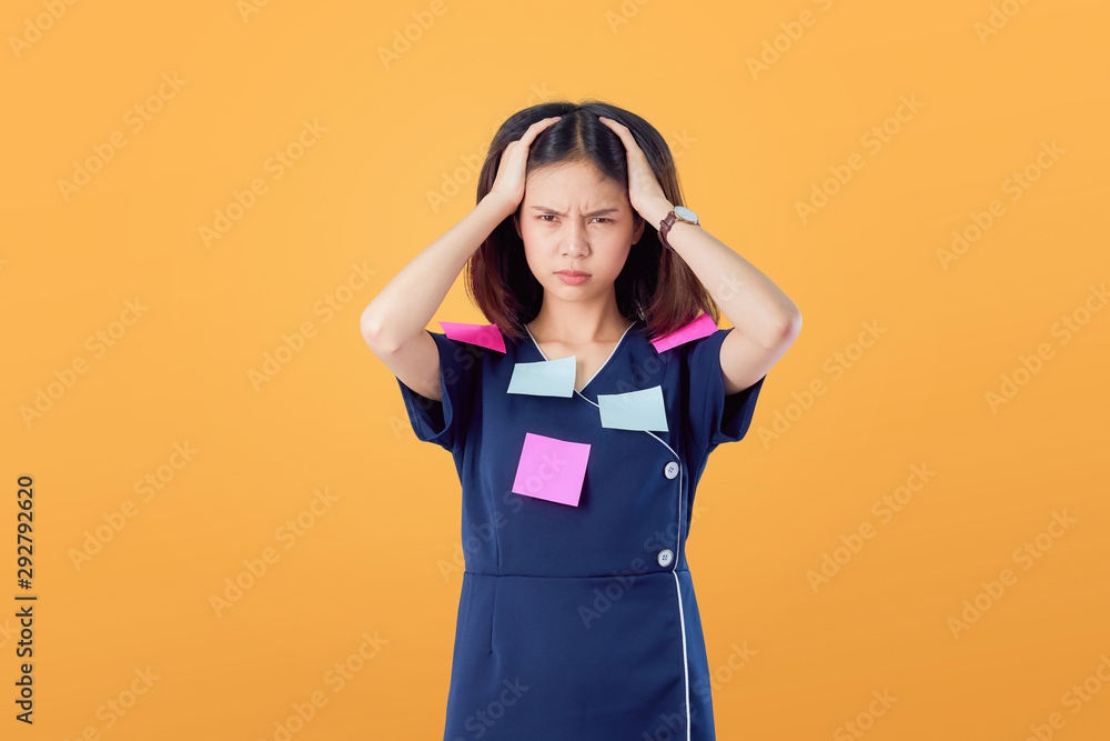 Unhappy young Asian woman standing with holding hair and feeling confused with something on orange background. Unhappy young Asian woman standing with holding hair and feeling confused with something on orange background.