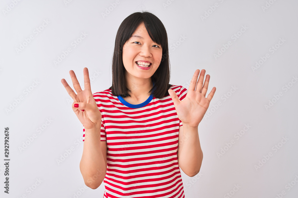 Young beautiful chinese woman wearing red striped t-shirt over isolated white background showing and pointing up with fingers number eight while smiling confident and happy. Young beautiful chinese woman wearing red striped t-shirt over isolated white background showing and pointing up with fingers number eight while smiling confident and happy.