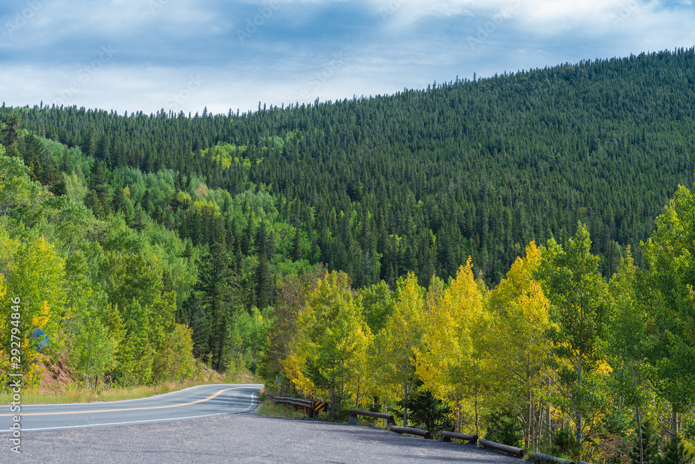 Low angle landscape of road in the mountains with aspen trees turning yellow near Idaho Springs, Colorado Low angle landscape of road in the mountains with aspen trees turning yellow near Idaho Springs, Colorado