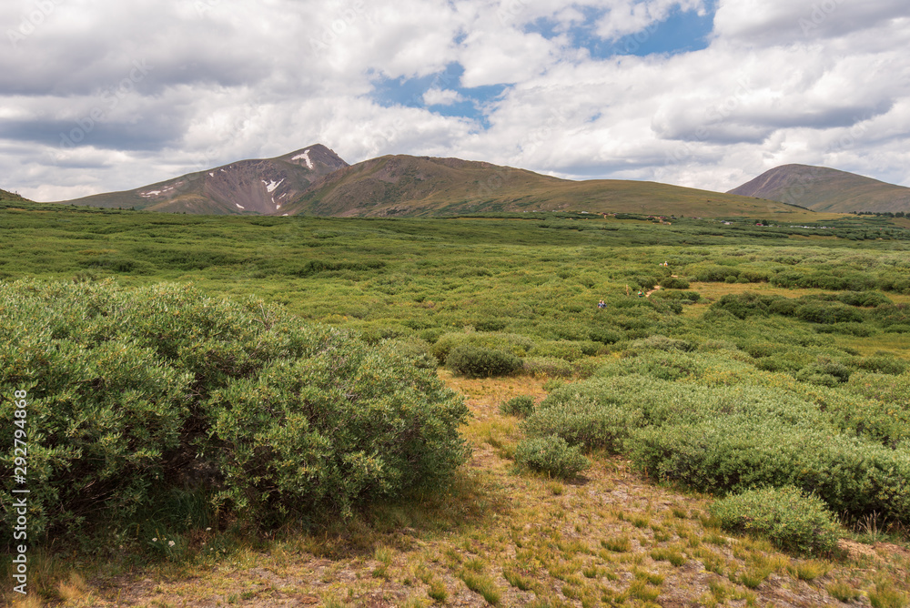 Alpine landscape of green meadow, mountain tops, and clouds at the top of Guanella Pass in Colorado Alpine landscape of green meadow, mountain tops, and clouds at the top of Guanella Pass in Colorado