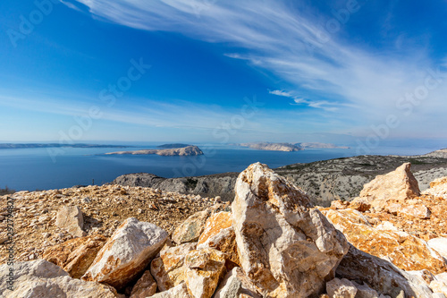 Off the Dalmatian coast of Croatia are a few isolated islands under a blue sky