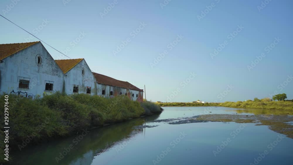 Abandoned factory with pond during sunrise at Tavira Portugal Abandoned factory with pond during sunrise at Tavira Portugal