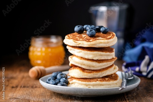 Pancakes with honey and blueberries. Stack of american buttermilk pancakes. Tasty breakfast