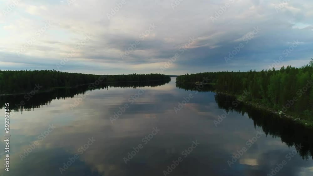 Northern river aerial scenes. Large wide river with islands covered with coniferous and mixed forests. Early morning, sun rises, clouds in the sky Northern river aerial scenes. Large wide river with islands covered with coniferous and mixed forests. Early morning, sun rises, clouds in the sky