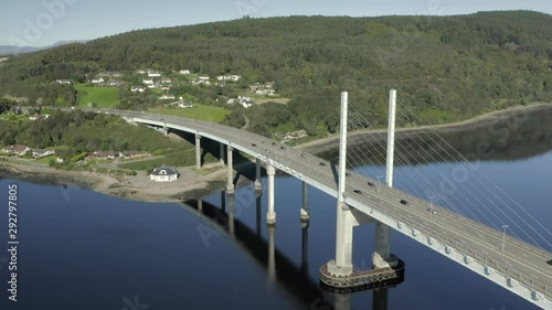 An aerial view of Kessock Bridge in Inverness on a sunny summer's morning. Flying towards the western and northern side of the bridge whilst zooming in. photo