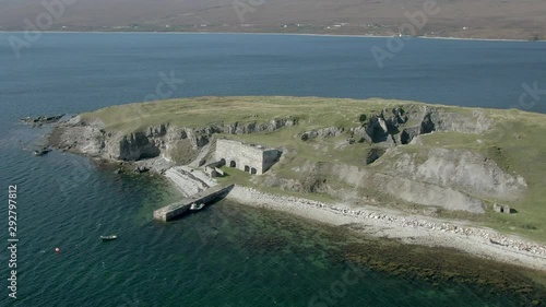 An aerial view of Ard Neakie abandoned lime kilns on a sunny summer's day. Rotating clockwise around the entrance to the kilns with zoom out. Wide view. photo