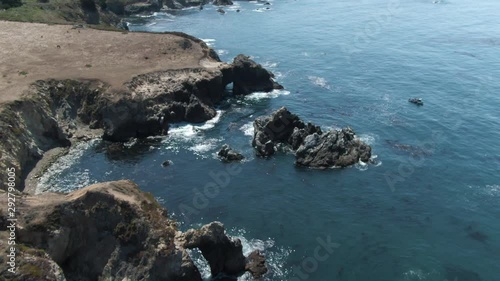 Wallpaper Mural Down tilt of huge rocks on shore of Pacific ocean near Highway 1 in California. Location is Notleys Landing Viewpoint. Clear blue skies, waves crashing on rocks, dark blue water. Torontodigital.ca