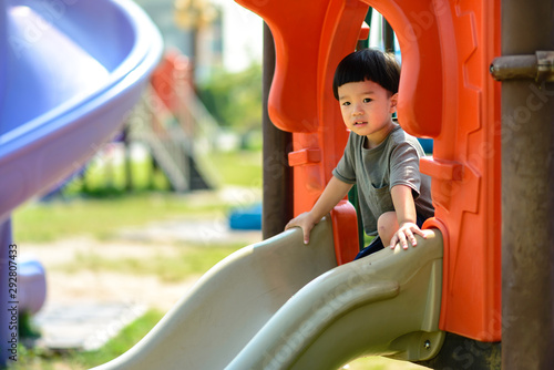 The asian boy is playing slider on the playground. Activities to build a good experience outside the home.