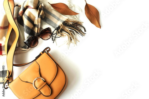 Autumn composition with women fashion  accessories top view on white background toned. Flat lay collage of female style look with bag, sunglasses, scarf,  autumn leaves. Copy space