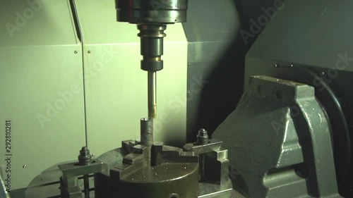 Tracking shot of an automated CNC machine doing precise cutting work in a factory (Kilang di Malaysia) photo