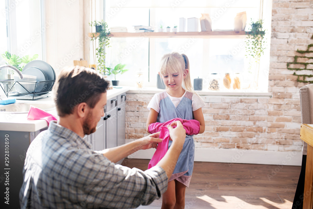 Father and daughter putting gloves on before cleaning kitchen Father and daughter putting gloves on before cleaning kitchen