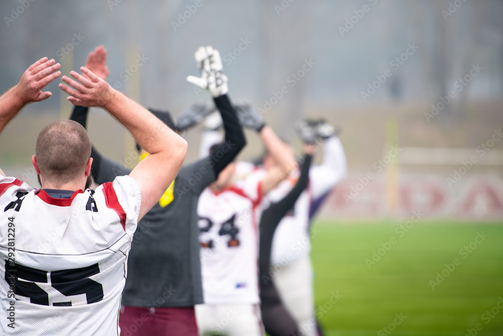 Fototapeta premium american football players stretching and warming up