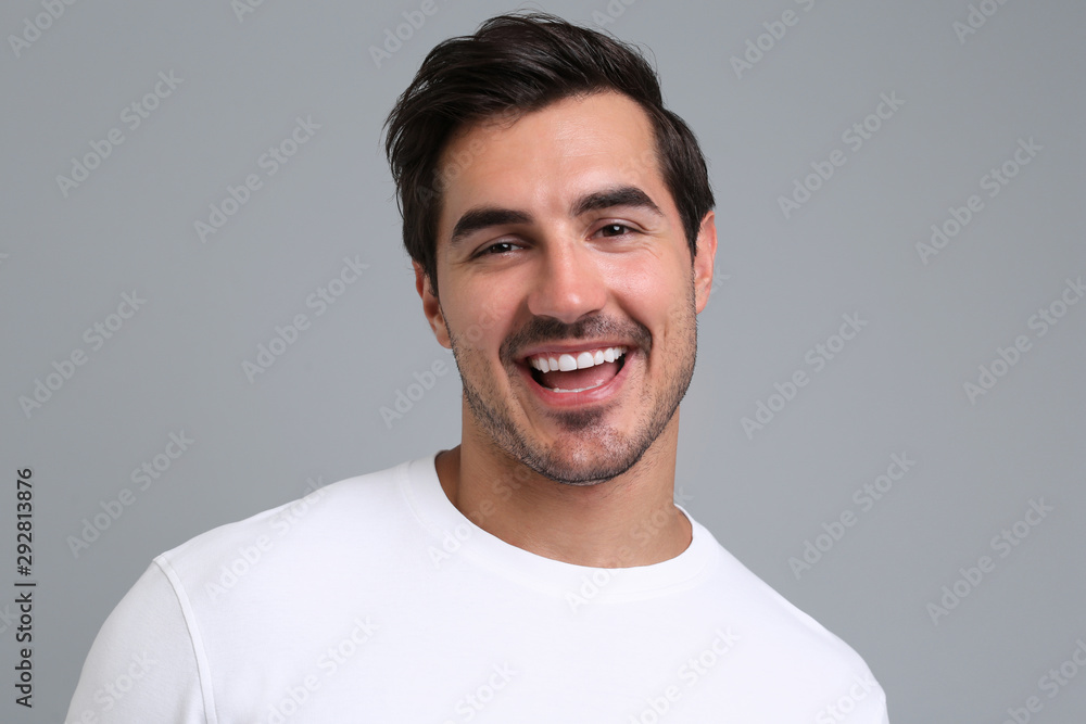Portrait of handsome young man in white t-shirt on grey background Portrait of handsome young man in white t-shirt on grey background