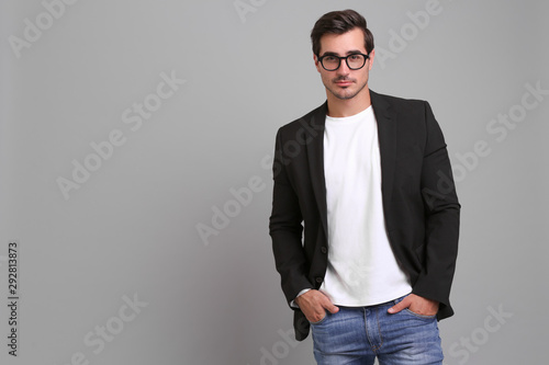 Handsome young man in casual clothes on grey background. Space for text