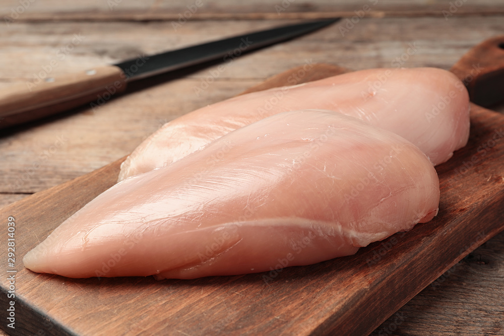 Fresh raw chicken meat on wooden cutting board Fresh raw chicken meat on wooden cutting board