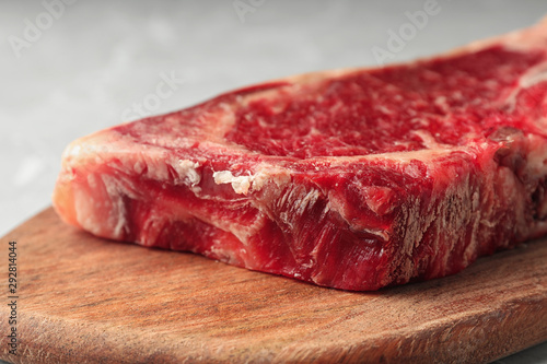 Raw beef meat on wooden board, closeup view