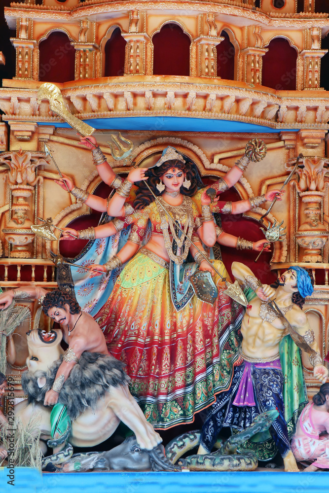 Fototapeta premium Goddess Durga idol at decorated Durga Puja pandal, shot at colored light, at Kolkata, West Bengal, India. Durga Puja is biggest religious festival of Hinduism and is now celebrated worldwide.