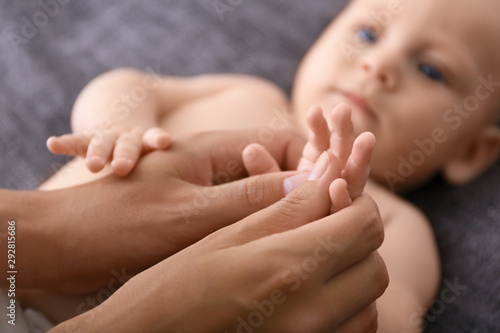 Bilde på lerret Woman massaging cute little baby on blanket, closeup