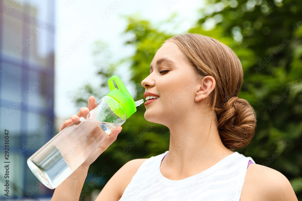 Young woman drinking water outdoors. Refreshing drink Young woman drinking water outdoors. Refreshing drink