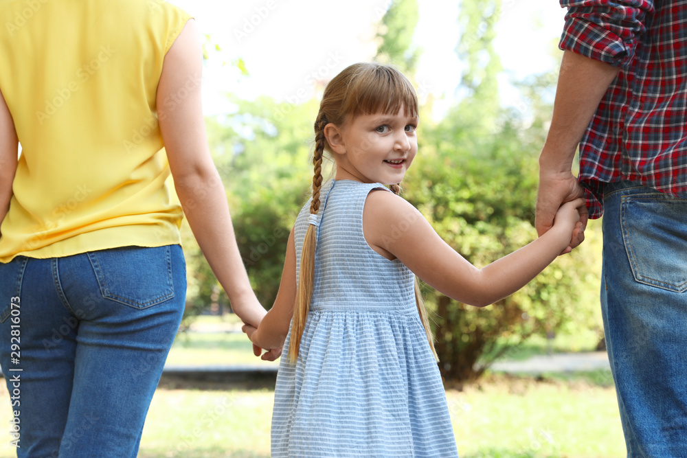 Little girl and her parents holding hands outdoors. Family weekend Little girl and her parents holding hands outdoors. Family weekend