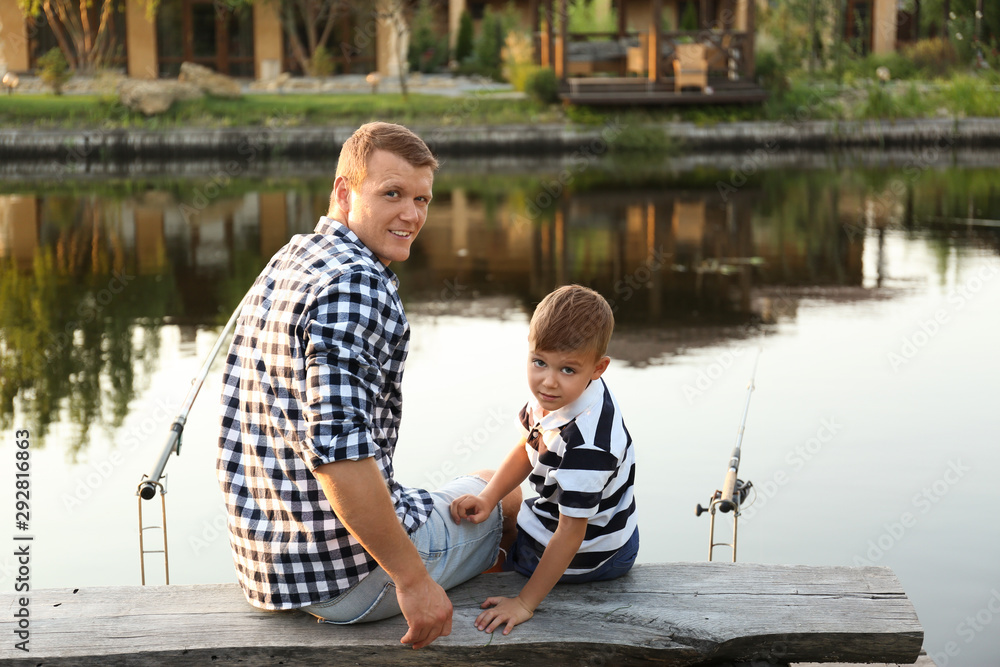 Dad and son fishing together on sunny day Dad and son fishing together on sunny day