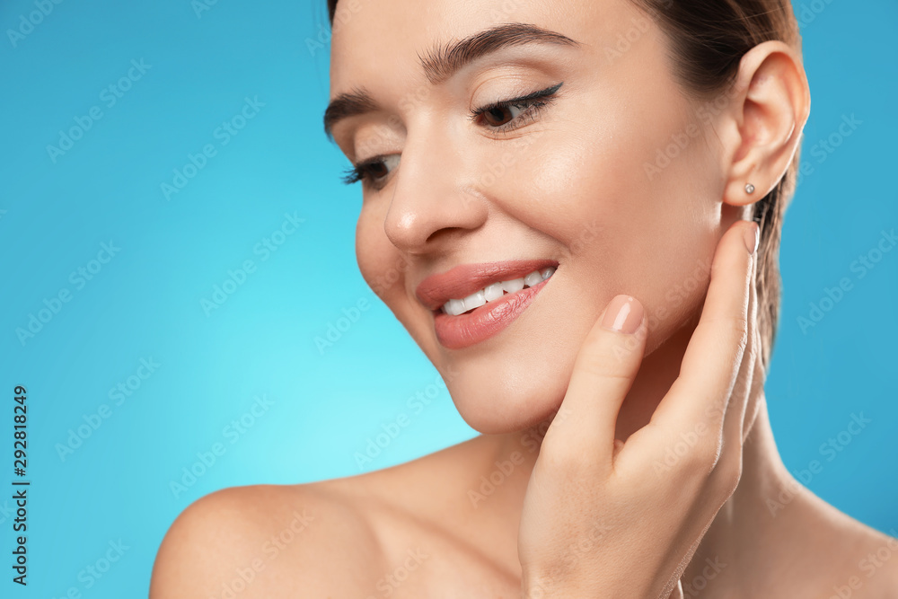 Obraz premium Beautiful woman with perfect smooth skin on light blue background, closeup