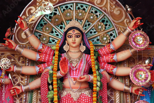 Goddess Durga idol at decorated Durga Puja pandal, shot at colored light, at Kolkata, West Bengal, India. Durga Puja is biggest religious festival of Hinduism and is now celebrated worldwide.