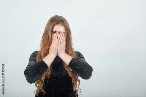 girl brown haired in black dress over isolated white background shows emotions