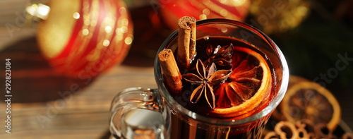 Christmas mulled vine with spices sinnamon stiks, anice stars, orange and New Year decorations on a wooden rustik table. Banner. Selective focus. Traditional hot drink at Xmas holiday photo