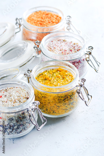 Four jars with different flavoured mixes of salt and spices. Himalayan and sea salt mixed with various peppers and herbs.