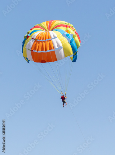 A parachute flies against a blue sky