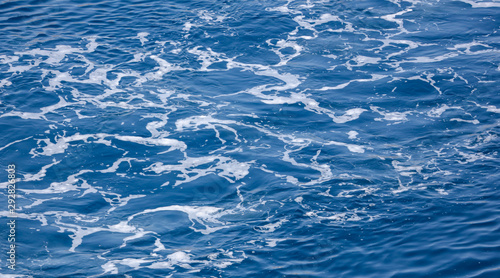 Waves from a boat in the blue water of the sea
