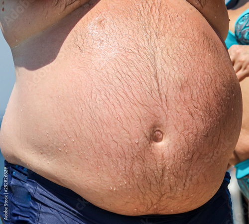 Big belly of a fat man on the beach
