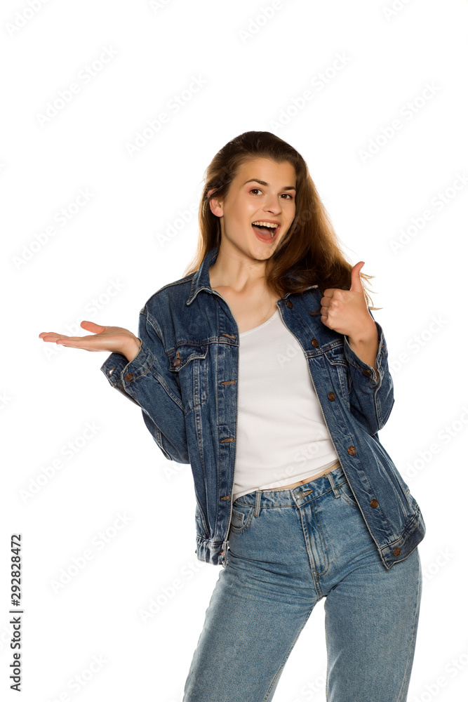 Young beautiful woman in jeans holding imaginary object on her hand on  white background Stock Photo | Adobe Stock