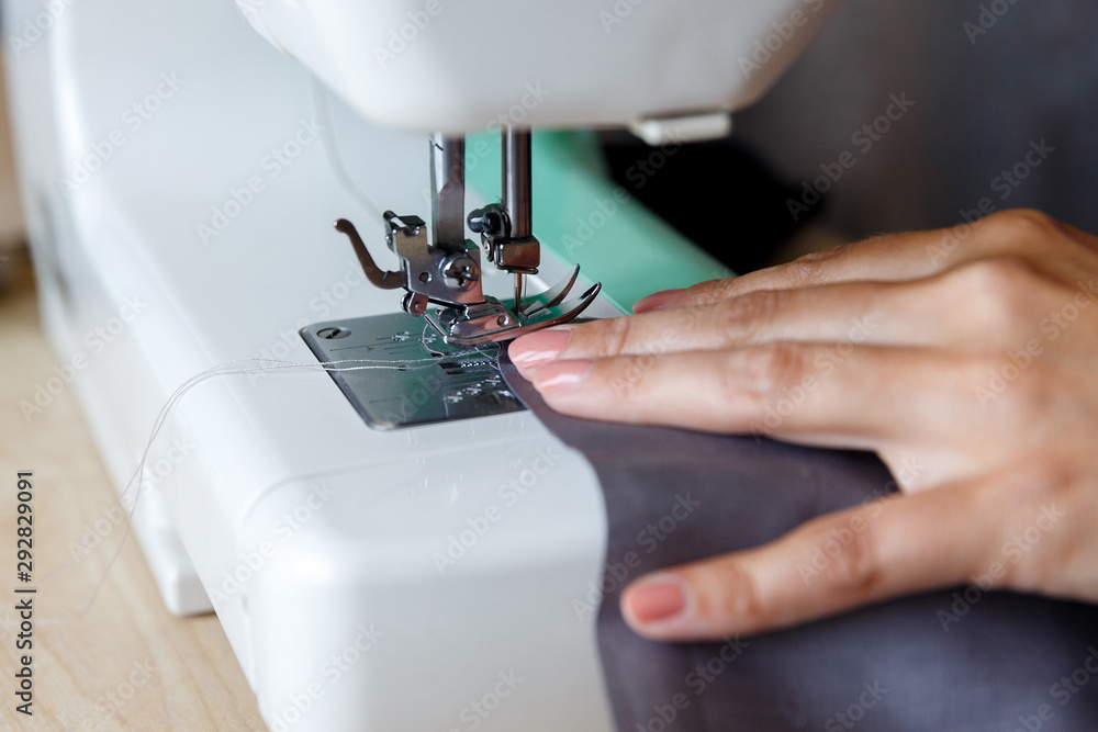 The working process. Seamstress sewing fabric on a sewing machine