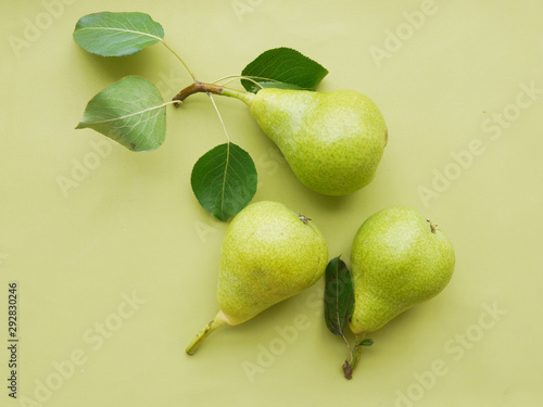 Green pears on a green background, top view, flat lay. Fruit pattern.